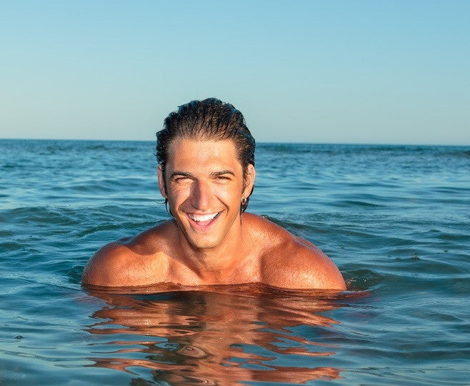 Man Smiling In Ocean using Skin Care For Men